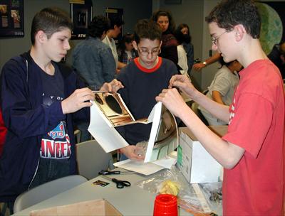 Students in the Young Astronaut Program at the Coca-Cola Space Science Center in Columbus, GA, constructed gloveboxes using the new NASA Student Glovebox Education Guide. The young astronauts used cardboard copier paper boxes as the heart of the glovebox. The paper boxes transformed into gloveboxes when the students pasted poster-pictures of an actual NASA microgravity science glovebox inside and outside of the paper boxes. The young astronauts then added holes for gloves and removable transparent top covers, which completed the construction of the gloveboxes. This image is from a digital still camera; higher resolution is not available.