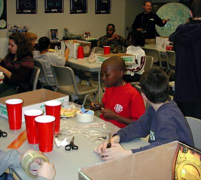 Students in the Young Astronaut Program at the Coca-Cola Space Science Center in Columbus, GA, constructed gloveboxes using the new NASA Student Glovebox Education Guide. The young astronauts used cardboard copier paper boxes as the heart of the glovebox. The paper boxes transformed into gloveboxes when the students pasted poster-pictures of an actual NASA microgravity science glovebox inside and outside of the paper boxes. The young astronauts then added holes for gloves and removable transparent top covers, which completed the construction of the gloveboxes. This image is from a digital still camera; higher resolution is not available.
