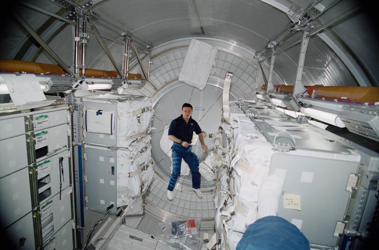 A crewmember of Expedition One, cosmonaut Yuri P. Gidzenko, is dwarfed by transient hardware aboard Leonardo, the Italian Space Agency-built Multi-Purpose Logistics Module (MPLM), a primary cargo of the STS-102 mission. The Leonardo MPLM is the first of three such pressurized modules that will serve as the International Space Station's (ISS's) moving vans, carrying laboratory racks filled with equipment, experiments and supplies to and from the Space Station aboard the Space Shuttle. The cylindrical module is approximately 21-feet long and 15- feet in diameter, weighing almost 4.5 tons. It can carry up to 10 tons of cargo into 16 standard Space Station equipment racks. Of the 16 racks the module can carry, 5 can be furnished with power, data, and fluid to support refrigerators or freezers. In order to function as an attached station module as well as a cargo transport, the logistics module also includes components that provide life support, fire detection and suppression, electrical distribution, and computer functions. The eighth Shuttle mission to visit the ISS, the STS-102 mission served as a crew rotation flight. It delivered the Expedition Two crew to the Station and returned the Expedition One crew back to Earth. 