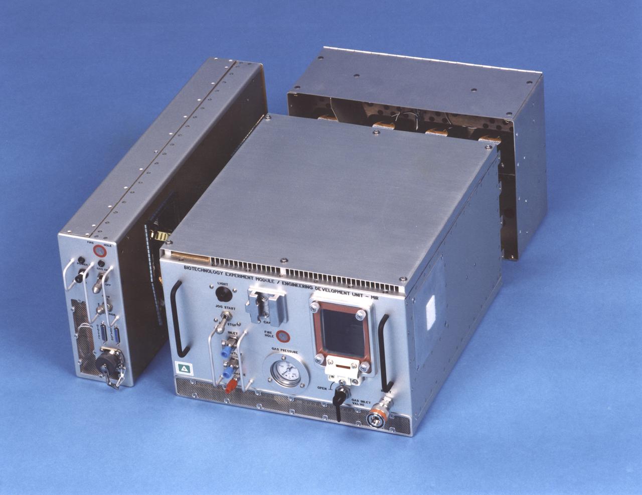 Exterior view of the NASA Bioreactor Engineering Development Unit flown on Mir. The rotating wall vessel is behind the window on the face of the large module. Control electronics are in the module at left; gas supply and cooling fans are in the module at back. The NASA Bioreactor provides a low turbulence culture environment which promotes the formation of large, three-dimensional cell clusters. The Bioreactor is rotated to provide gentle mixing of fresh and spent nutrient without inducing shear forces that would damage the cells. Due to their high level of cellular organization and specialization, samples constructed in the bioreactor more closely resemble the original tumor or tissue found in the body. The work is sponsored by NASA's Office of Biological and Physical Research. The bioreactor is managed by the Biotechnology Cell Science Program at NASA's Johnson Space Center (JSC). NASA-sponsored bioreactor research has been instrumental in helping scientists to better understand normal and cancerous tissue development. In cooperation with the medical community, the bioreactor design is being used to prepare better models of human colon, prostate, breast and ovarian tumors. Cartilage, bone marrow, heart muscle, skeletal muscle, pancreatic islet cells, liver and kidney are just a few of the normal tissues being cultured in rotating bioreactors by investigators.