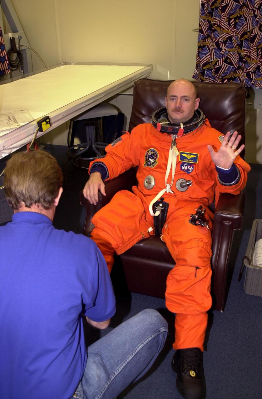 KENNEDY SPACE CENTER, Fla. -- STs-108 Pilot Mark E. Kelly is helped with his launch and entry suit in preparation for the second launch attempt of Space Shuttle Endeavour. The first attempt Dec. 4 was scrubbed due to poor weather conditions at KSC. The main goals of the mission are to carry the Expedition 4 crew to the International Space Station as replacement for Expedition 3; carry the Multi-Purpose Logistics Module Raffaello filled with water, equipment and supplies; and install thermal blankets over equipment at the base of the ISS solar wings. STS-108 is the final Shuttle mission of 2001 and the 107th Shuttle flight overall. It is the 12th flight to the Space Station. Launch is scheduled for 5:19 p.m. EST (22:19 GMT) Dec. 5, 2001, from Launch Pad 39B