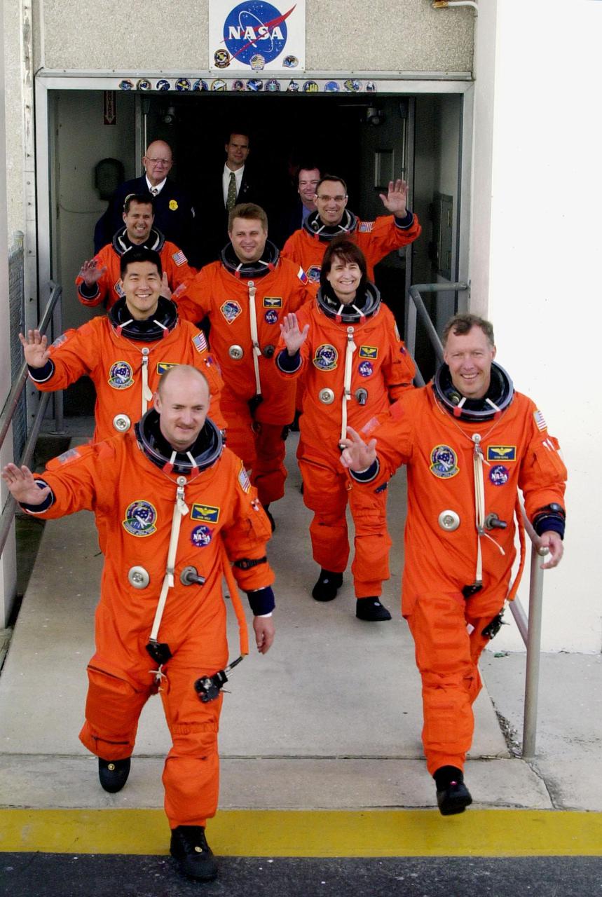 KENNEDY SPACE CENTER, Fla. -- Eagerly stepping out from the Operations and Checkout Building are the STS-108 crew, leading the way, and the Expedition 4 crew as they head for Launch Pad 39B and Space Shuttle Endeavour. From front to back are, left to right, Pilot Mark E. Kelly and Commander Dominic L. Gorie; Mission Specialists Daniel M. Tani and Linda A. Godwin; Expedition 4 members Daniel W. Bursch, Commander Yuri Onufrienko and Carl E. Walz. This is the second launch attempt after the first attempt Dec. 4 was scrubbed due to poor weather conditions at KSC. The main goals of the mission are to carry the Expedition 4 crew to the International Space Station as replacement for Expedition 3; carry the Multi-Purpose Logistics Module Raffaello filled with water, equipment and supplies; and install thermal blankets over equipment at the base of the ISS solar wings. STS-108 is the final Shuttle mission of 2001 and the 107th Shuttle flight overall. Launch is scheduled for 5:19 p.m. EST (22:19 GMT) Dec. 5, 2001, from Launch Pad 39B