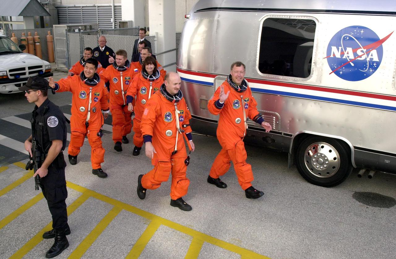 KENNEDY SPACE CENTER, Fla. -- The STS-108 and Expedition 4 crews head for the Astrovan and a ride to Launch Pad 39B. Leading the way are Pilot Mark E. Kelly (left) and Commander Dominic L. Gorie; behind them are Mission Specialists Daniel M. Tani and Linda A. Godwin; next is Expedition 4 Commander Yuri Onufrienko, followed by astronauts Daniel W. Bursch (left) and Carl E. Walz. This is the second launch attempt after the first attempt Dec. 4 was scrubbed due to poor weather conditions at KSC. The main goals of the mission are to carry the Expedition 4 crew to the International Space Station as replacement for Expedition 3; carry the Multi-Purpose Logistics Module Raffaello filled with water, equipment and supplies; and install thermal blankets over equipment at the base of the ISS solar wings. STS-108 is the final Shuttle mission of 2001 and the 107th Shuttle flight overall. Launch is scheduled for 5:19 p.m. EST (22:19 GMT) Dec. 5, 2001, from Launch Pad 39B