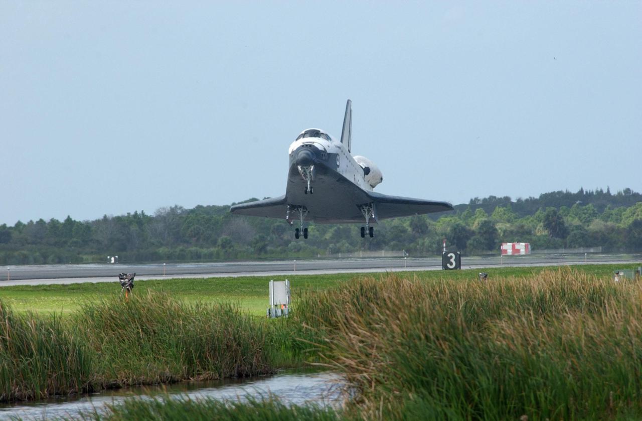 KENNEDY SPACE CENTER, FLA. - After dropping through cloud cover, Orbiter Endeavour approaches Runway 15 at the KSC Shuttle Landing Facility, with a mission elapsed time of 11 days, 19 hours, 35 minutes.  Main gear touchdown occurred at 12:55:10 p.m. EST, nose gear touchdown at 12:55:23 p.m. , wheel stop at 12:56:13 p.m.  The landing, the 57th at KSC in the history of the program completed the STS-108 mission known as Utilization Flight 1, which was the 12th mission to the International Space Station.  This mission was the 107th flight in the Shuttle program and the 17th flight for the orbiter.  Endeavour carries both the mission crew and the Expedition 3 crew - Commander Frank Culbertson and cosmonauts Vladimir Dezhurov and Mikhail Tyurin - who are returning to Earth after 129 days in space on the Space Station