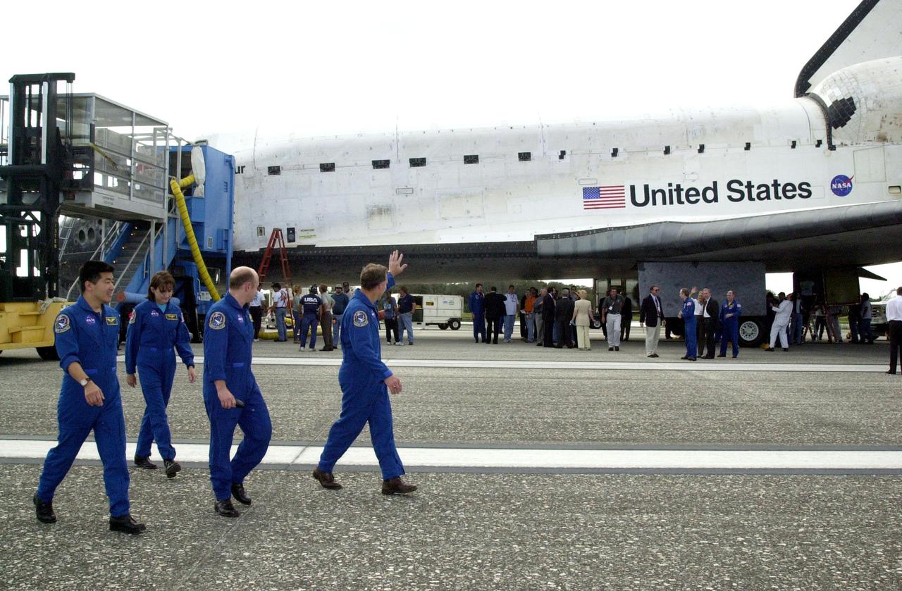 KENNEDY SPACE CENTER, FLA. --  The STS-108 crew wave to the crowd as they head for the van to transport them back to crew quarters.   The crew completed their mission with a successful landing on Runway 15 of the KSC Shuttle Landing Facility.  The mission had an elapsed time of 11 days, 19 hours and 35 minutes. Main gear touchdown occurred at 12:55:10 p.m. EST (17:55:10 GMT), nose gear touchdown at 12:55:23 p.m. (17:55:23 GMT) , wheel stop at 12:56:13 p.m. (17:56:13 GMT). Rollout distance was 8,941 feet.  Endeavour carried both the mission crew and the Expedition 3 crew - Commander Frank Culbertson and cosmonauts Vladimir Dezhurov and Mikhail Tyurin - who returned to Earth after 129 days in space on the Space Station.  STS-108 was the 12th mission to the International Space Station.  This mission was the 107th flight in the Shuttle program and the 17th flight for the orbiter. The landing is the 57th at KSC in the history of the program
