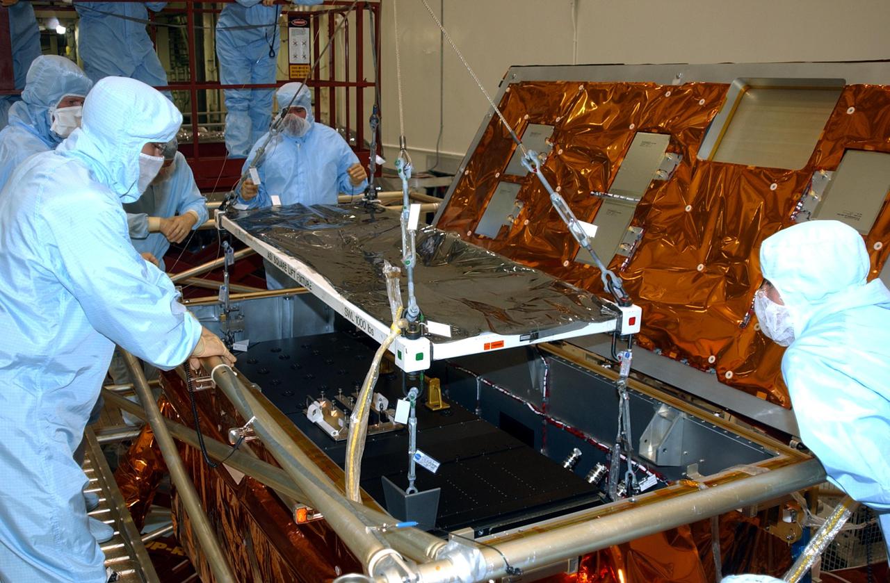 KENNEDY SPACE CENTER, FLA. -- In the Vertical Processing Facility, workers watch while the Advanced Camera for Surveys (ACS) is lowered into the Axial Science Instrument Protective Enclosure (ASIPE). The ACS is part of the payload on the Hubble Space Telescope Servicing Mission, STS-109. The goal of the mission is to service the HST, replacing Solar Array 2 with Solar Array 3, replacing the Power Control Unit, removing the Faint Object Camera and installing the ACS, installing the Near Infrared Camera and Multi-Object Spectrometer (NICMOS) Cooling System, and installing New Outer Blanket Layer insulation. Mission STS-109 is scheduled for launch no earlier than Feb. 21, 2002