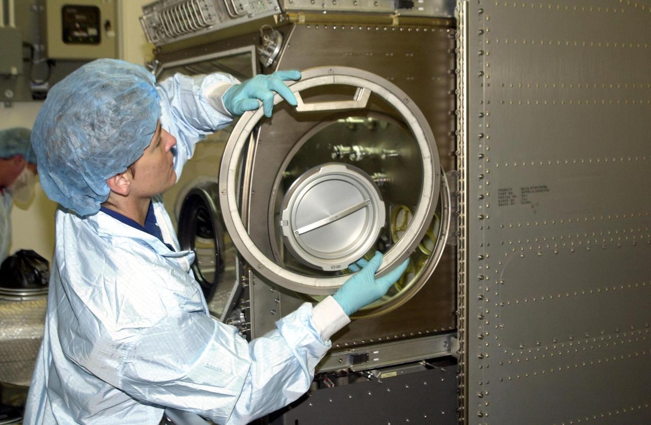 KENNEDY SPACE CENTER, FLA. -- Astronaut Peggy Whitson, a member of the Expedition 5 crew, looks over equipment in the Space Station Processing Facility. She and other crew members Commander Valeri Korzun and Sergei Treschev will be traveling to the International Space Station on mission STS-111 and will be replacing the Expedition 4 crew. Part of the payload on STS-111 will be the Mobile Base System, to be installed installed on the Mobile Transporter to complete the Canadian Mobile Servicing System, or MSS. The mechanical arm will then have the capability to 'inchworm' from the U.S. Lab fixture to the MSS and travel along the Truss to work sites. STS-111 is scheduled to launch in May 2002
