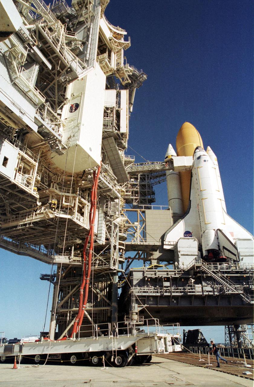 KENNEDY SPACE CENTER, Fla. -- At the launch pad, a payload canister carrying the Multi-Purpose Logistics Module Raffaello is lifted up the Rotating Service Structure (left) to the Payload Changeout Room. From there the MPLM will be moved into Space Shuttle Endeavour's payload bay. The Shuttle with its external tank and one solid rocket booster is seen at right. Endeavour is scheduled to launch Nov. 29 on the first Utilization Flight to the International Space Station. Raffaello is filled with supplies and equipment for the Station. Endeavour will also carry the replacement Expedition 4 crew to the Station and return to Earth with the Expedition 3 crew