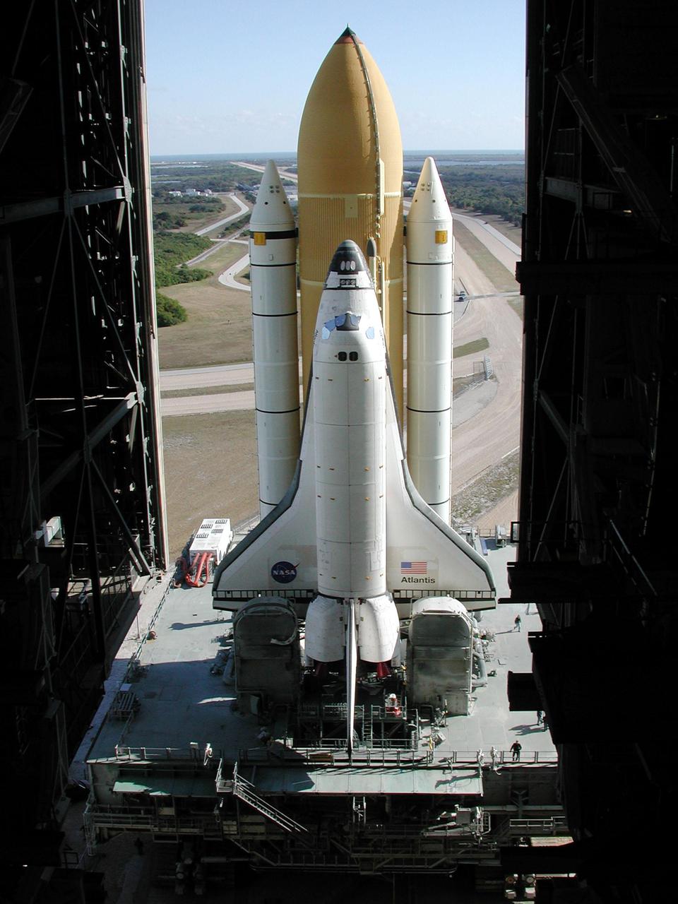 KENNEDY SPACE CENTER, Fla. -- Space Shuttle Atlantis, on its Mobile Launcher Platform, begins rolling through the open doors of the Vehicle Assembly Building to Launch Pad 39A, this time on another crawler transporter. An attempt to roll out on Jan. 2 incurred a failed computer processor on the first crawler transporter. The Shuttle was returned to the VAB using a secondary computer processor on the vehicle. Atlantis will fly on mission STS-98, the seventh construction flight to the International Space Station, carrying the U.S. Laboratory, named Destiny. The lab module will have five system racks already installed inside. After delivery of electronics in the lab, electrically powered attitude control for Control Moment Gyroscopes will be activated. Atlantis is scheduled for launch no earlier than Jan. 19, 2001, with a crew of five