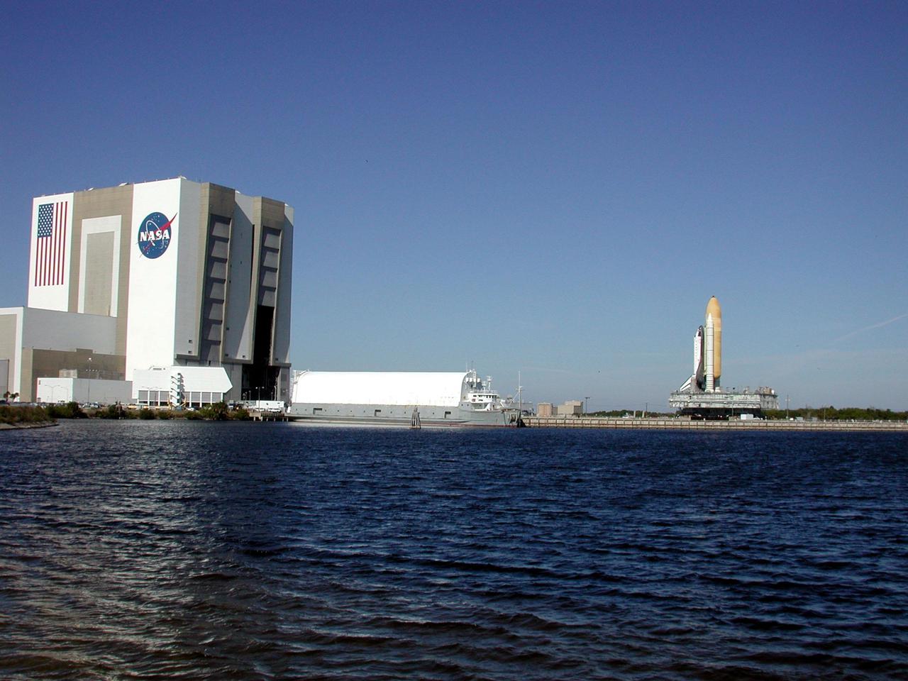 KENNEDY SPACE CENTER, Fla. -- Space Shuttle Atlantis, on its Mobile Launcher Platform, is seen from across the turn basin as it rolls out to Launch Pad 39A for the second time. An attempt to roll out on Jan. 2 incurred a failed computer processor on the first crawler transporter. The Shuttle was returned to the VAB using a secondary computer processor on the vehicle. Atlantis will fly on mission STS-98, the seventh construction flight to the International Space Station, carrying the U.S. Laboratory, named Destiny. The lab module will have five system racks already installed inside. After delivery of electronics in the lab, electrically powered attitude control for Control Moment Gyroscopes will be activated. Atlantis is scheduled for launch no earlier than Jan. 19, 2001, with a crew of five