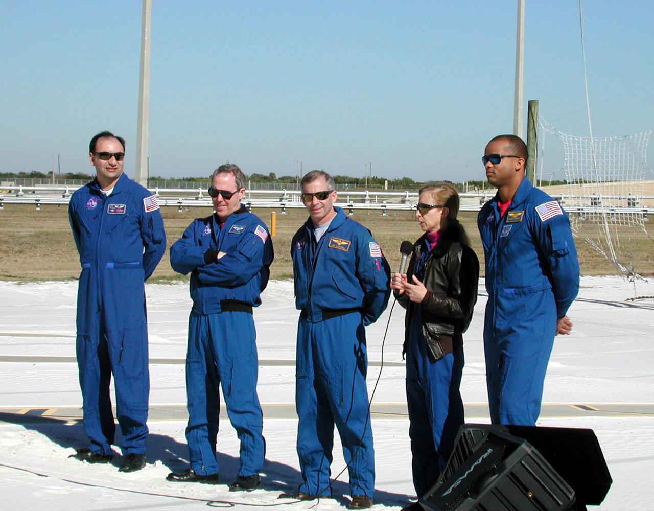 KENNEDY SPACE CENTER, Fla. -- The STS-98 crew talks to the press at a briefing at Launch Pad 39A. With the microphone is Mission Specialist Marsha Ivins, who discusses her role in the mission using the robotic arm to move the payload into position. The other crew members are (left to right) Pilot Mark Polansky, Mission Specialist Thomas Jones, Commander Ken Cockrell and Mission Specialist Robert Curbeam (far right). They are at KSC to take part in Terminal Countdown Demonstration Test activities, which also include a simulated launch countdown. STS-98 is the seventh construction flight to the International Space Station, carrying as payload the U.S. Lab Destiny, a key element in the construction of the ISS. Launch of STS-98 is scheduled for Jan. 19 at 2:11 a.m