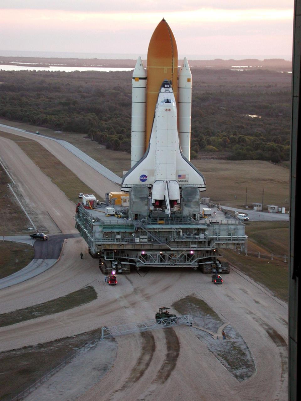 KENNEDY SPACE CENTER, Fla. -- In the early morning light, Space Shuttle Atlantis makes the turn from the Vehicle Assembly Building onto the crawlerway for the trek to Launch Pad 39A. The Shuttle has been in the VAB undergoing tests on the solid rocket booster cables. A prior extensive evaluation of NASA’s SRB cable inventory on the shelf revealed conductor damage in four (of about 200) cables. Shuttle managers decided to prove the integrity of the system tunnel cables already on Atlantis, causing return of the Shuttle to the VAB a week ago. Launch of Atlantis on STS-98 has been rescheduled to Feb. 7 at 6:11 p.m. EST