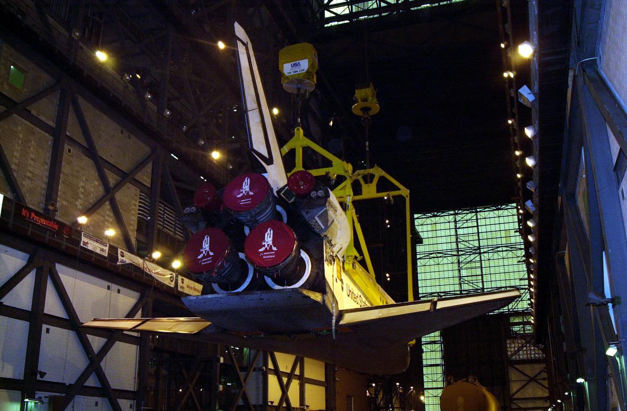 In the transfer aisle of the Vehicle Assembly Building, the orbiter Discovery (seen from the back) is lifted to vertical. It will then be lifted up and into high bay 1 for mating with its solid rocket boosters and external tank. Discovery will be launched March 8 on mission STS-102, the eighth construction flight to the International Space Station. The Shuttle will carry the Multi-Purpose Logistics Module Leonardo, the first of three pressurized modules provided by the Italian Space Agency to carry supplies and equipment to the Space Station and back to earth