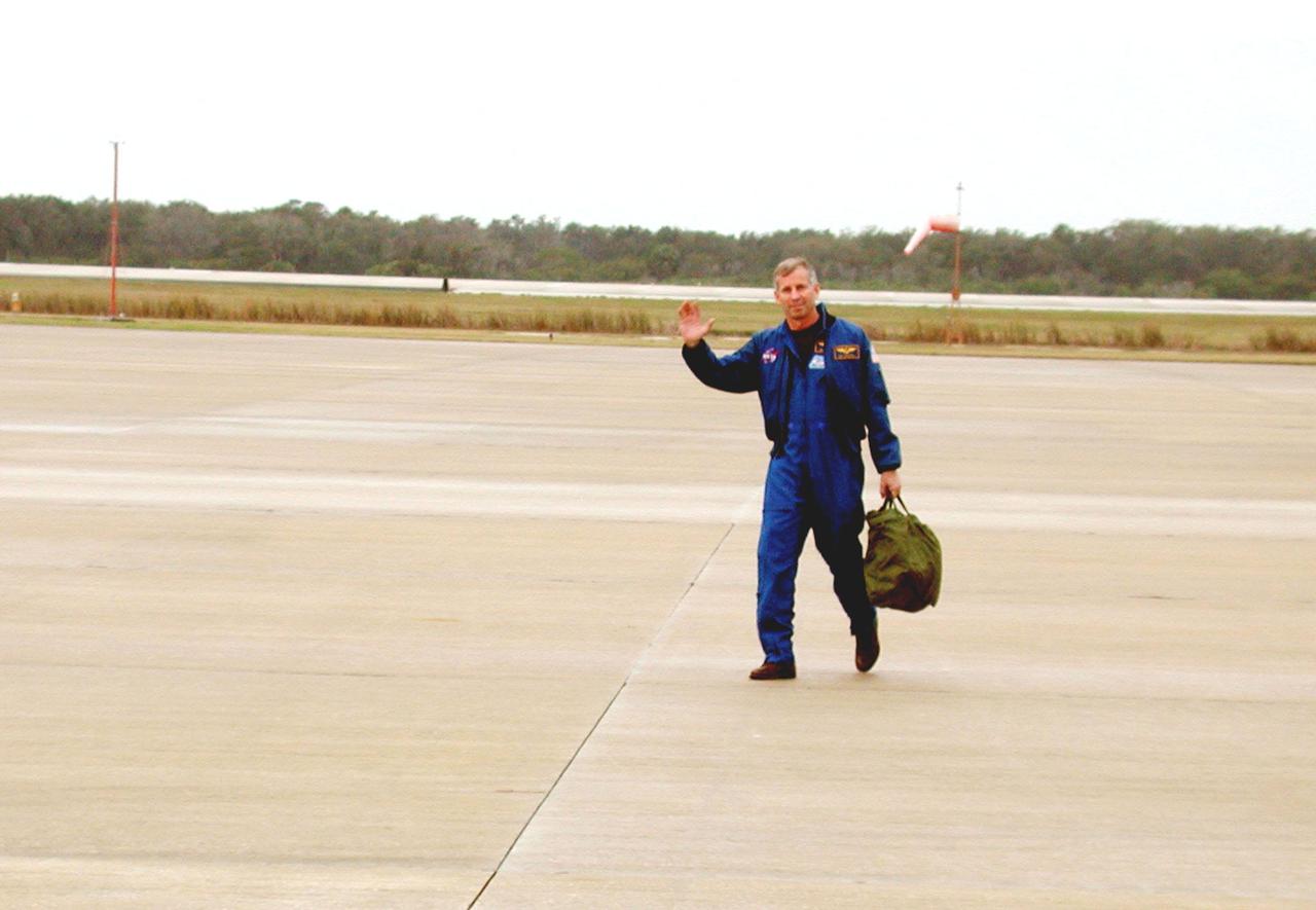 KENNEDY SPACE CENTER, FLA. -- STS-98 Commander Ken Cockrell waves as he crosses the parking apron of the Shuttle Landing Facility after a flight on the Shuttle Training Aircraft. The cockpit of the STA is outfitted like the Shuttle, which provides practice at the controls, especially for landing. The STS-98 crew recently arrived at KSC to prepare for their launch Feb. 7 to the International Space Station. The seventh construction flight to the Space Station, it will carry the U.S. Laboratory Destiny, a key module for space experiments