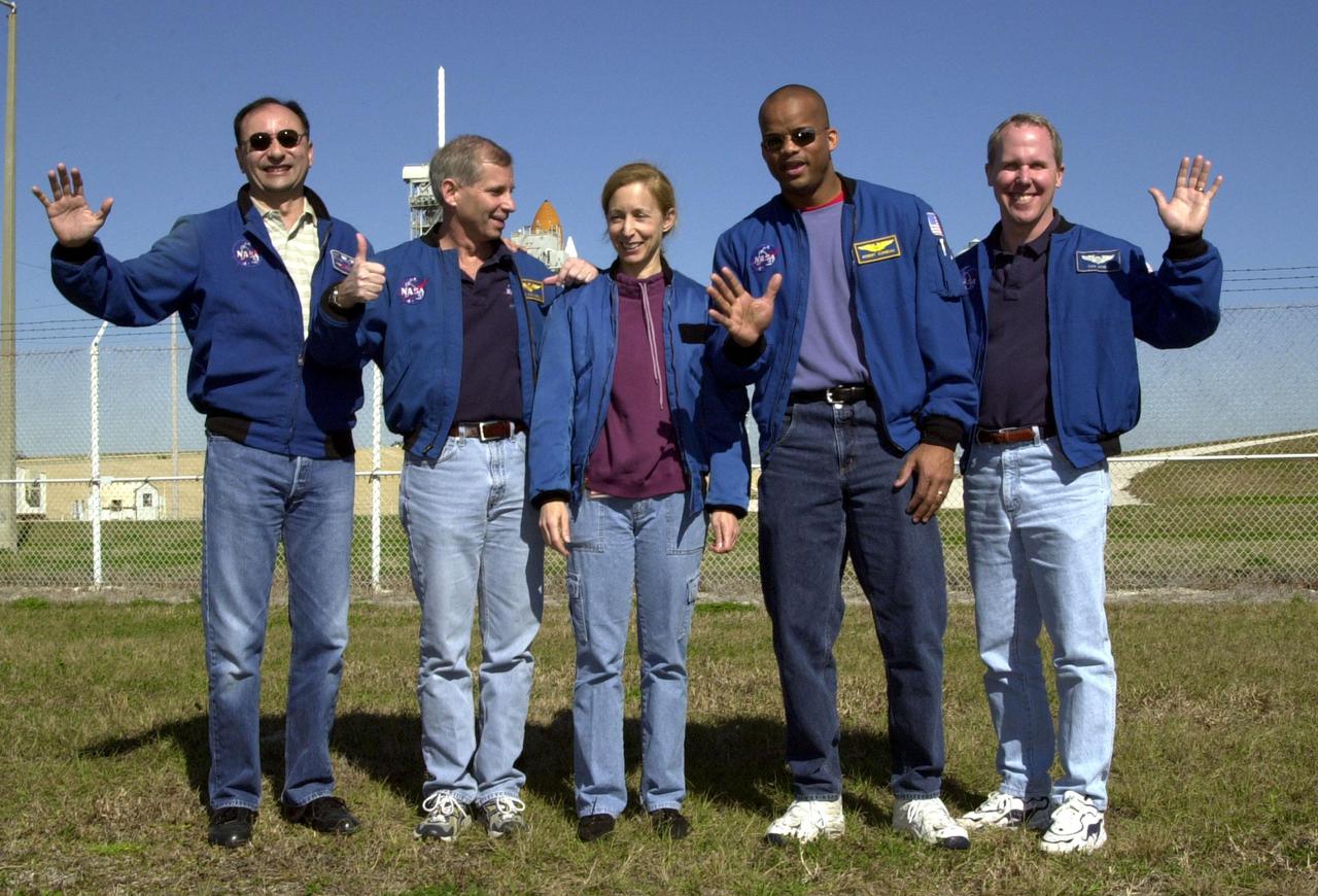 The STS-98 crew, gathered at Launch Pad 39A one day before launch, wave and give a thumbs up. From left, they are Pilot Mark Polansky, Commander Ken Cockrell and Mission Specialists Marsha Ivins, Robert Curbeam and Thomas Jones. Behind them is Space Shuttle Atlantis, poised for launch.This mission marks the seventh Shuttle flight to the International Space Station and the first Shuttle mission of the year. On the mission, the crew will deliver the U.S. Laboratory Destiny to the growing Space Station. Destiny will be attached to the Unity node using the Shuttle’s robotic arm. Three spacewalks are required to complete the planned construction work. The 11-day STS-98 mission is scheduled to launch Feb. 7 at 6:11 p.m. EST, with a planned KSC landing about 1:39 p.m. on Feb. 18