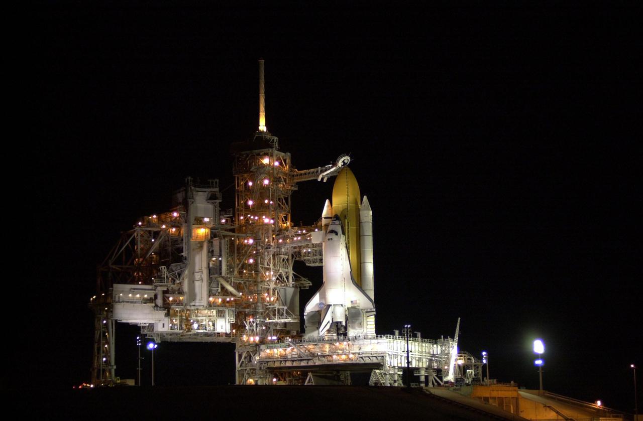 KENNEDY SPACE CENTER, Fla. -- Lights on the Fixed Service Structure give a holiday impression at Launch Pad 39A where Space Shuttle Atlantis is poised for launch. Above the yellow-orange external tank is the Gaseous Oxygen Vent Arm, with the “beanie cap” vent hood raised. Before cryogenic loading, the hood will be lowered into position over the external tank vent louvers to vent gaseous oxygen vapors away from the Shuttle. Atlantis is carrying the U.S. Laboratory Destiny, a key module in the growth of the International Space Station. Destiny will be attached to the Unity node on the Space Station using the Shuttle’s robotic arm. Three spacewalks are required to complete the planned construction work during the 11-day mission. Launch is targeted for 6:11 p.m. EST and the planned landing at KSC Feb. 18 about 1:39 p.m. This mission marks the seventh Shuttle flight to the Space Station, the 23rd flight of Atlantis and the 102nd flight overall in NASA’s Space Shuttle program