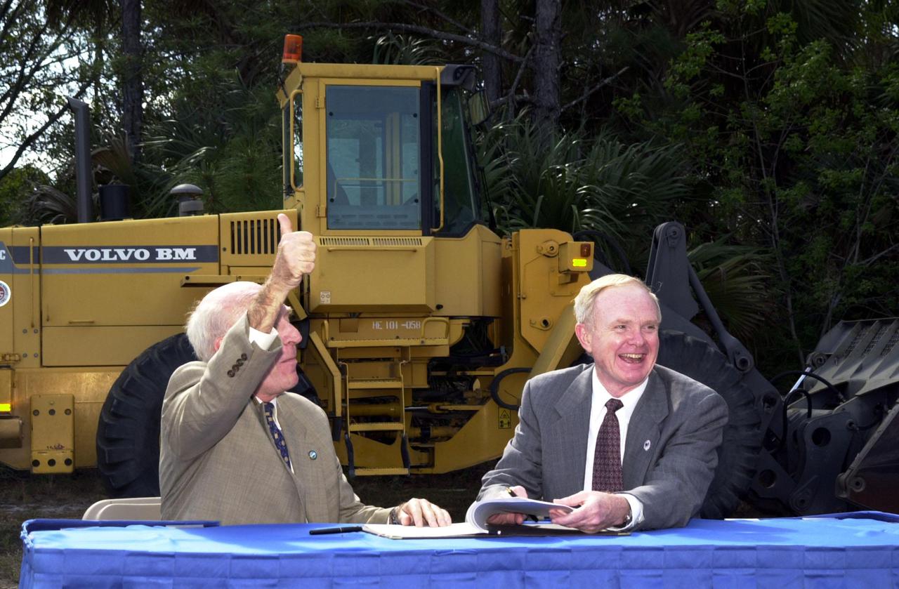 During a signing ceremony, Ed Gormel (left), executive director of Spaceport Florida Authority, and Roy Bridges Jr., Center Director, respond to a remark from the audience. The two are signing a SERPL Real Property Use Permit Agreement between the two organizations to construct a three-mile roadway. It is the start of a construction project that includes the Space Experiment Research and Processing Laboratory (SERPL). The signing took place outdoors on S.R. 3 prior to a groundbreaking ceremony for the roadway. The road, to be known as Space Commerce Way, will serve the public by providing a 24-hour access route through KSC from S.R. 3 to the NASA Causeway and KSC Visitor Complex. The SERPL project is enabled by a partnership and collaboration between NASA and the State of Florida to create a vital resource for international and commercial space customers. SERPL is considered a magnet facility, and will support the development and processing of life sciences experiments destined for the International Space Station and accommodate NASA, industry and academic researchers performing associated biological research