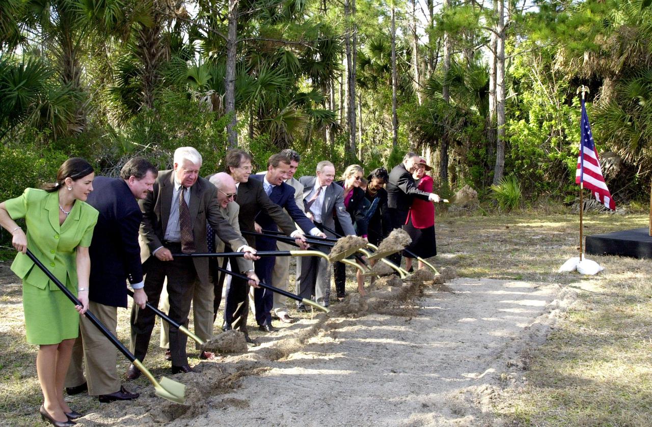 At a groundbreaking ceremony, participants and guests toss their shovelfuls of dirt, signifying the start of construction on a new roadway through KSC. From left are Dr. Pamella J. Dana, from the executive office of Florida’s governor, Jeb Bush; Deputy Associate Administrator Michael Hawes, NASA; Sen. George Kirkpatrick; Spaceport Florida Authority Executive Director Ed Gormel; Executive Director Dr. Samuel T. Durrance, Florida Space Research Institute; Florida’s Lt. Gov. Frank Brogan; Congressman Dave Weldon; Center Director Roy Bridges Jr.; SFA SERPL Program Manager Debra Holliday; KSC SERPL Program Manager Jan Heuser; District Manager Cheryl Harrison-Lee, Florida Department of Transportation; State Senator Jim Sebesta; and KSC Director JoAnn H. Morgan, External Relations and Business Development The roadway, to be known as Space Commerce Way, will serve the public by providing a 24-hour access route through KSC from S.R. 3 to the NASA Causeway and KSC Visitor Complex. It is the start of a construction project that includes the Space Experiment Research and Processing Laboratory (SERPL). Considered a magnet facility, the laboratory will support the development and processing of life sciences experiments destined for the International Space Station and accommodate NASA, industry and academic researchers performing associated biological research.. The project is enabled by a partnership and collaboration between NASA and the State of Florida to create a vital resource for international and commercial space customers