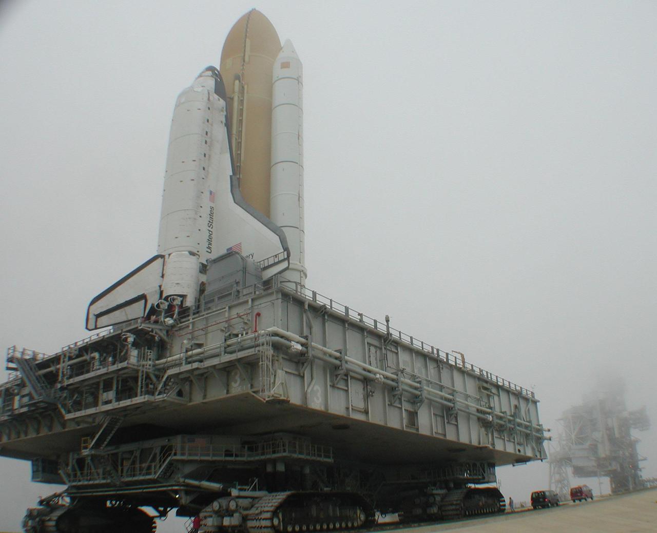 KENNEDY SPACE CENTER, Fla. -- Space Shuttle Discovery, on its Mobile Launcher Platform, inches up the ramp to Launch Pad 39B. Fog has rolled in over the pad, blurring the lines of the Fixed Service Structure (background right). Discovery will be flying on mission STS-102 to the International Space Station. Its payload is the Multi-Purpose Logistics Module Leonardo, a “moving van,” to carry laboratory racks filled with equipment, experiments and supplies to and from the Space Station aboard the Space Shuttle. The flight will also carry the Expedition Two crew up to the Space Station, replacing Expedition One, who will return to Earth on Discovery. Launch is scheduled for March 8 at 6:45 a.m. EST