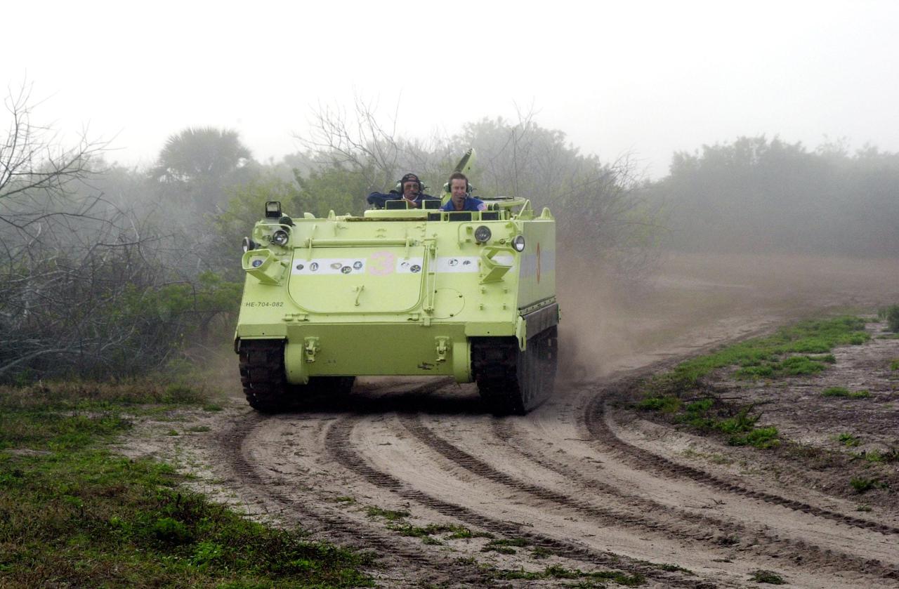 STS-102 Commander James Wetherbee practices driving an M-113 armored carrier, part of emergency egress training at Launch Pad 39B. Seated alongside is Capt. George Hoggard (left), a training officer with SGS Fire Services. In the event of an emergency at the pad prior to launch, the carrier could be used to transport the crew to a nearby bunker or farther. The STS-102 crew is at KSC to take part in Terminal Countdown Demonstration Test activities, which also include a simulated launch countdown. STS-102 is the eighth construction flight to the International Space Station, carrying as payload the Multi-Purpose Logistics Module Leonardo. Launch on mission STS-102 is scheduled for March 8