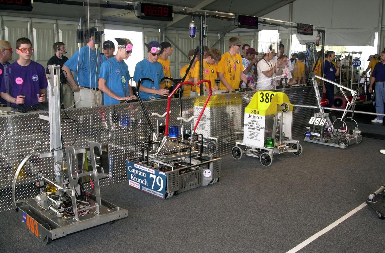 Student teams get ready to move their robots on the playing field during the NASA_KSC FIRST Southeastern Regional event held March 1-3, 2001. Starting from left, robot number 493, “Dukes,” is controlled by students from Marlington High School, Alliance, Ohio. It is a KSC joint-sponsored team. Team 79, the “Navigators,” are from East Lake High School, Clearwater, Fla. Team 386, “Voltage: South Brevard FIRST Team,” represents six schools in Brevard County, Fla. Team 168, Flashbacks, represent North Miami Beach Senior High School and Michael Kropp High School, North Miami, Fla. Voltage and Flashbacks are KSC joint-sponsored teams. FIRST (For Inspiration and Recognition of Science and Technology) events are held nationwide, pitting robots against each other and the clock on a playing field. Many teams are sponsored by corporations and academic institutions. There are 27 teams throughout the State of Florida who are competing. KSC, which sponsors nine teams, has held the regional event for two years