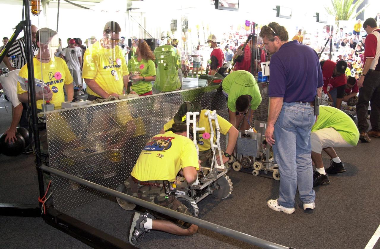 Student teams adjust their robots before competing on the playing field field during the NASA_KSC FIRST Southeastern Regional event held March 1-3, 2001. At left is the ComBBAT 2001 team from Astronaut and Titusville High Schools, Florida. It is a KSC joint-sponsored team. At right is the PC Panthers, no. 710, from Pine Crest School, Fort Lauderdale, Fla. FIRST (For Inspiration and Recognition of Science and Technology) events are held nationwide, pitting robots against each other and the clock on a playing field. Many teams are sponsored by corporations and academic institutions. There are 27 teams throughout the State of Florida who are competing. KSC, which sponsors nine teams, has held the regional event for two years