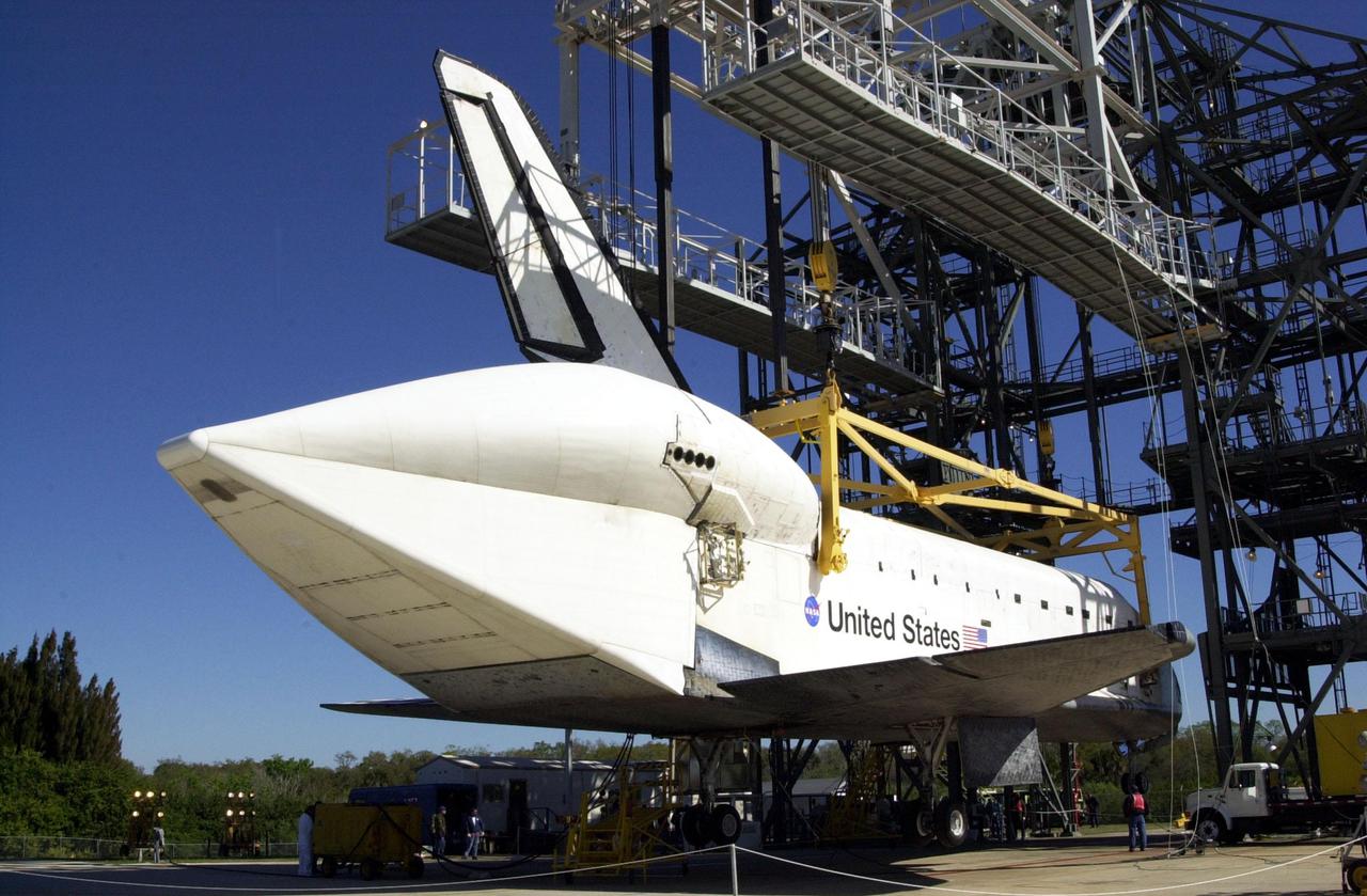 KENNEDY SPACE CENTER, FLA. -- An overhead crane in the mate_demate device at KSC’s Shuttle Landing Facility lowers orbiter Atlantis onto its wheels. A tail cone covers the aft engines. Atlantis was removed from the back of a Shuttle Carrier Aircraft after a ferry flight from California. Atlantis landed Feb. 19 at Edwards Air Force Base concluding mission STS-98. The ferry flight began March 1; unfavorable weather conditions kept it on the ground at Altus AFB, Okla., until it could return to Florida. Atlantis will be transported to the Orbiter Processing Facility to prepare it for mission STS-104, the 10th construction flight to the International Space Station, scheduled to launch June 8