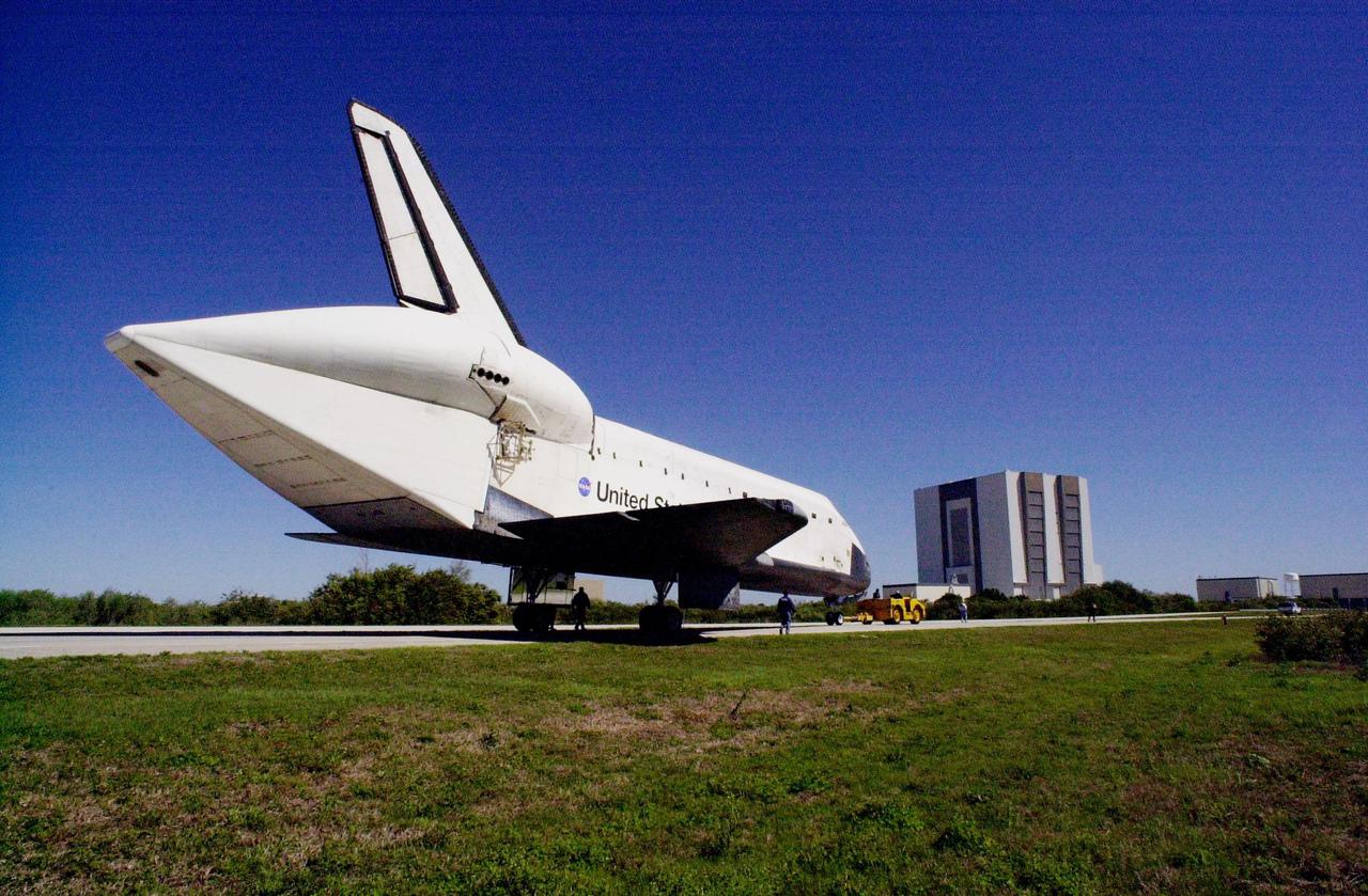 KENNEDY SPACE CENTER, FLA. -- Orbiter Atlantis is towed to the Orbiter Processing Facility bay 3 along the tow-way. In the background is the Vehicle Assembly Building. The unusual silhouette of the aft section on the orbiter is due to the tail cone covering the aft engines. Atlantis landed Feb. 19 at Edwards Air Force Base concluding mission STS-98. The orbiter returned to Florida on the back of a Shuttle Carrier Aircraft, known as a ferry flight, that began March 1. Unfavorable weather conditions kept it on the ground at Altus AFB, Okla., for several days until it could return to Florida. Atlantis will be prepared in the OPF for mission STS-104, the 10th construction flight to the International Space Station, scheduled to launch June 8