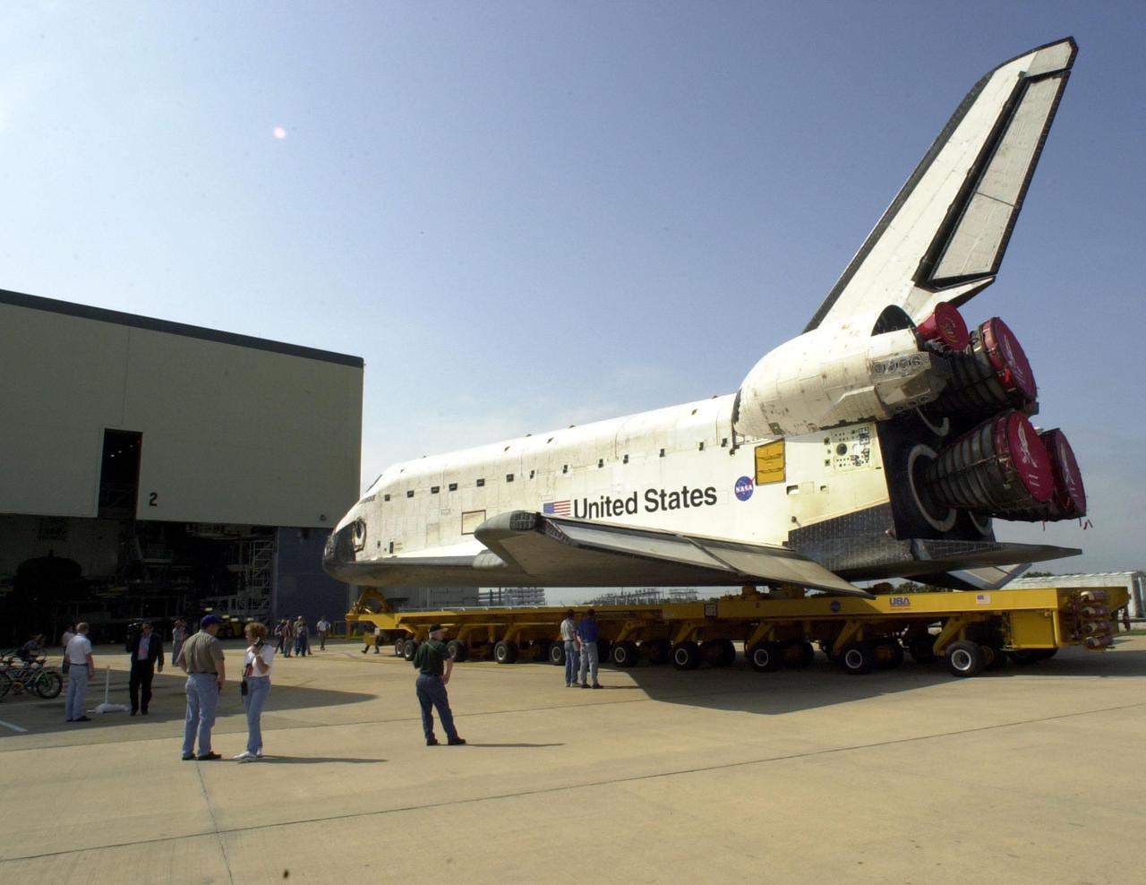 KENNEDY SPACE CENTER, FLA. -- Workers gather to watch the rollover of Endeavour to the Vehicle Assembly Building. Here the orbiter is backing out of the Orbiter Processing Facility bay 2. In the VAB Endeavour will be stacked with its solid rocket boosters and external tank atop the Mobile Launcher Platform. Endeavour is scheduled to launch April 19 on mission STS-100, the ninth flight to the International Space Station