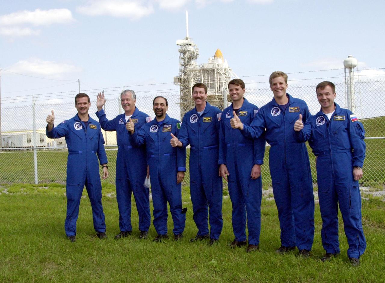KENNEDY SPACE CENTER, FLA. -- The STS-100 crew gives thumbs up on launch as they gather near Launch Pad 39A to greet family and friends. Starting at left, they are Mission Specialists Chris A. Hadfield, John L. Phillips and Umberto Guidoni; Commander Kent V. Rominger; Pilot Jeffrey S. Ashby; and Mission Specialists Scott E. Parazynski and Yuri V. Lonchakov. Hadfield is with the Canadian Space Agency; Guidoni is with the European Space Agency; and Lonchakov is with the Russian Aviation and Space Agency. In the background on the pad can be seen the tips of Space Shuttle Endeavour’s orange external tank and white solid rocket boosters. The 80-foot lightning rod towers above the Shuttle and service structures. The crew is at KSC to complete final flight plan reviews in anticipation of launch. The 11-day mission to the International Space Station will deliver and integrate the Spacelab Logistics Pallet_Launch Deployment Assembly, which includes the Space Station Remote Manipulator system and the UHF Antenna, and the Multi-Purpose Logistics Module Raffaello. The mission includes two planned spacewalks for installation of the SSRMS. The mission is also the inaugural flight of the MPLM Raffaello, carrying resupply stowage racks and resupply_return stowage platforms. Liftoff on mission STS-100 is scheduled at 2:41 p.m. EDT April 19