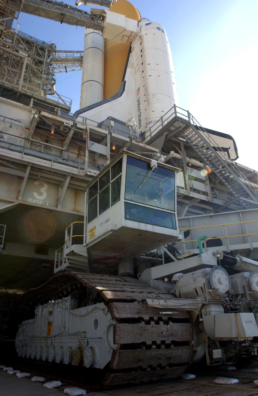KENNEDY SPACE CENTER, Fla. - This closeup shows the crawler-transporter (bottom) as it rolls out from under Space Shuttle Discovery and the mobile launcher platform on Launch Pad 39A. The operator can be seen in the control cab. The crawler-transporter earlier moved the Shuttle and MLP from the Vehicle Assembly Building on a six-hour journey of 3.4 miles. Discovery is scheduled to launch in early August on mission STS-105.   Photo by Scott Andrews using a Nikon D1X camera