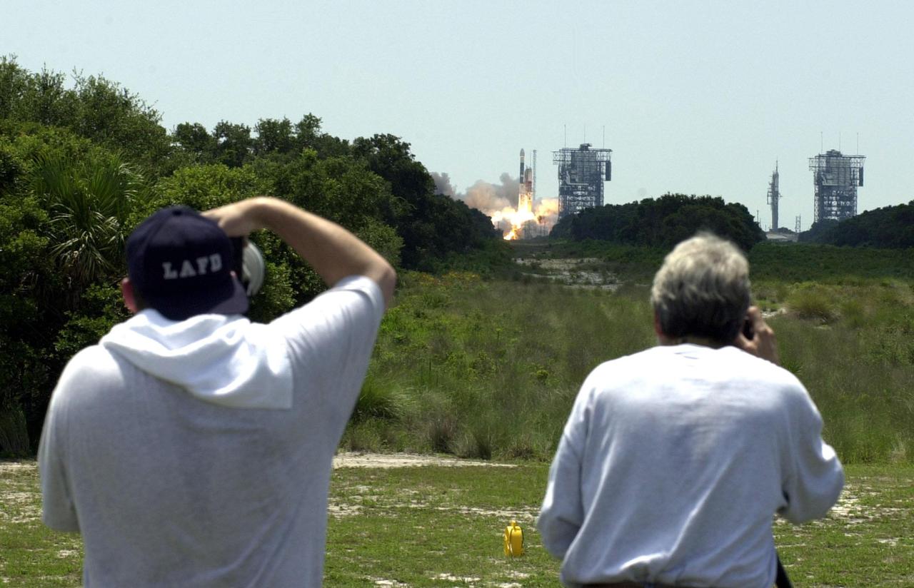 KENNEDY SPACE CENTER, Fla. -- Photographers take aim as the Boeing Delta II rocket propels NASA’s Genesis spacecraft into the sky on a journey to collect and return to Earth just 10 to 20 micrograms of solar wind, invisible charged particles that flow outward from the Sun. The particles will be studied by scientists over the next century to search for answers to fundamental questions about the exact composition of our star and the birth of our solar system. The Genesis_Delta launch occurred ontime at 12:13:40 p.m. EDT from Launch Complex 17-A, Cape Canaveral Air Force Station