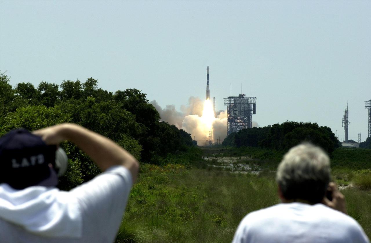 KENNEDY SPACE CENTER, Fla. -- The Boeing Delta II rocket propels NASA’s Genesis spacecraft into the sky as photographers take aim. The Genesis_Delta launch occurred ontime at 12:13:40 p.m. EDT from Launch Complex 17-A, Cape Canaveral Air Force Station. Genesis is on a journey to collect and return to Earth just 10 to 20 micrograms of solar wind, invisible charged particles that flow outward from the Sun. The particles will be studied by scientists over the next century to search for answers to fundamental questions about the exact composition of our star and the birth of our solar system