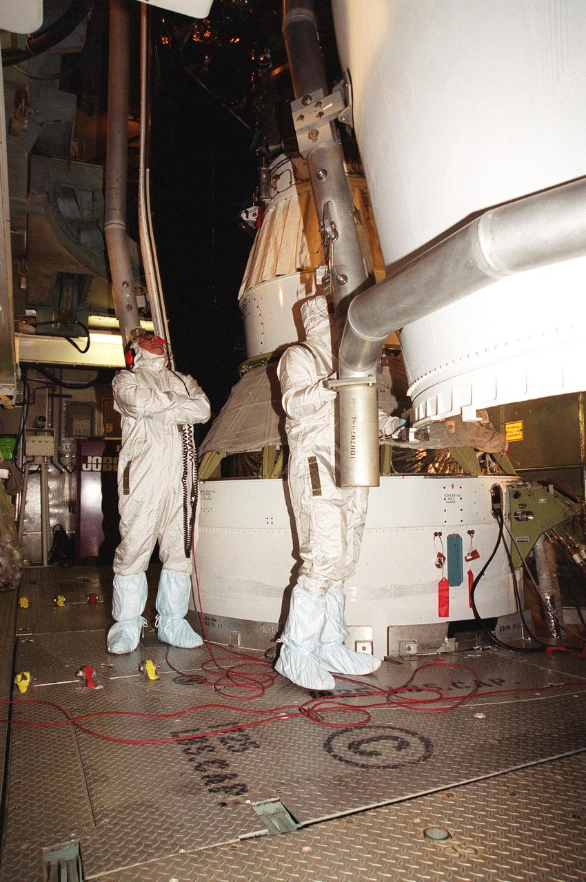 KENNEDY SPACE CENTER, Fla. -- Workers at Launch Complex 17-B, Cape Canaveral Air Force Station, oversee the fairing installation on the Microwave Anisotropy Probe (MAP) spacecraft. MAP is scheduled for launch on June 30 aboard a Boeing Delta II rocket. The launch will place MAP into a lunar-assisted trajectory to the Sun-Earth for a 27-month mission. The probe will measure small fluctuations in the temperature of the cosmic microwave background radiation to an accuracy of one millionth of a degree. These measurements should reveal the size, matter content, age, geometry and fate of the universe. They will also reveal the primordial structure that grew to form galaxies and will test ideas about the origins of these primordial structures. The MAP instrument will be continuously shaded from the Sun, Earth, and Moon by the spacecraft