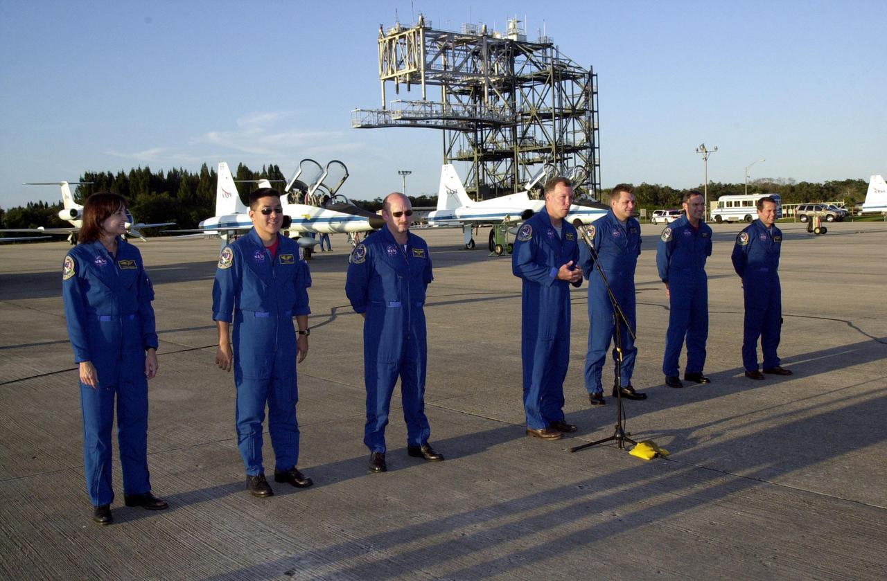 KENNEDY SPACE CENTER, Fla. -- On the parking apron at KSC's Shuttle Landing Facility, the STS-108 and Expedition 4 crews pause after their arrival to greet the media. Standing, left to right, are Mission Specialists Linda A. Godwin and Daniel M. Tani, Pilot Mark E. Kelly, and Commander Dominic L. Gorie; Expedition 4 Commander Yuri Onufrienko and crew members Carl E. Walz and Daniel W. Bursch. Top priorities for the STS-108 (UF-1) mission of Endeavour are rotation of the International Space Station Expedition Three and Expedition Four crews, bringing water, equipment and supplies to the station in the Multi-Purpose Logistics Module Raffaello, and completion of spacewalk and robotics tasks. Tani and Godwin will take part in the spacewalk to install thermal blankets over two pieces of equipment at the bases of the Space Station's solar wings. Liftoff is scheduled for 7:41 p.m. EST