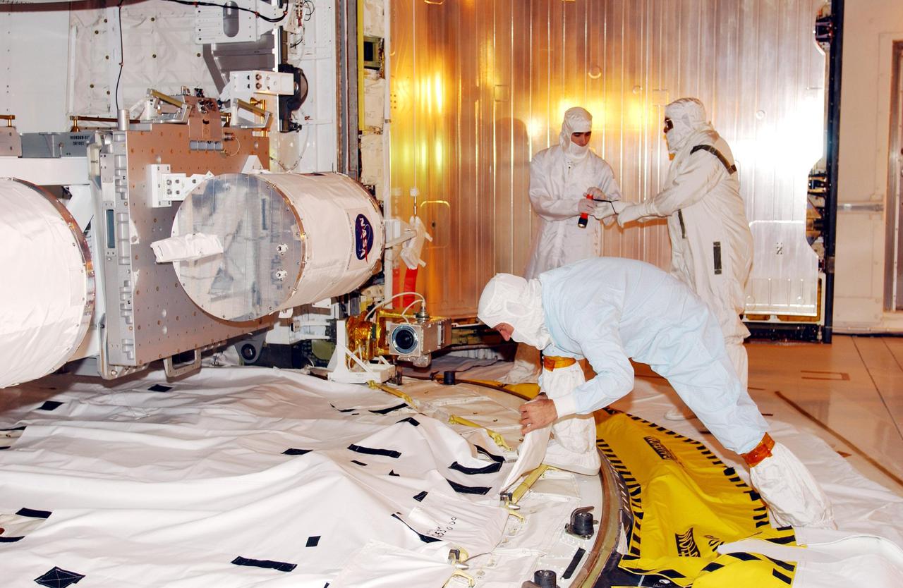 KENNEDY SPACE CENTER, Fla. - A worker makes a final adjustment in the payload bay of Space Shuttle Endeavour before door closure. Inside the bay is the Multi-Purpose Logistics Module Raffaello (foreground), carrying supplies, equipment and experiments for the International Space Station. Sharing the payload bay are several carriers with varying experiment packages, such as Starshine-2, a Get-Away Special. Endeavour is scheduled to launch Nov. 29 on this first Utilization Flight, STS-108, to the International Space Station. Endeavour will also carry the replacement Expedition 4 crew to the Station and return to Earth with the Expedition 3 crew