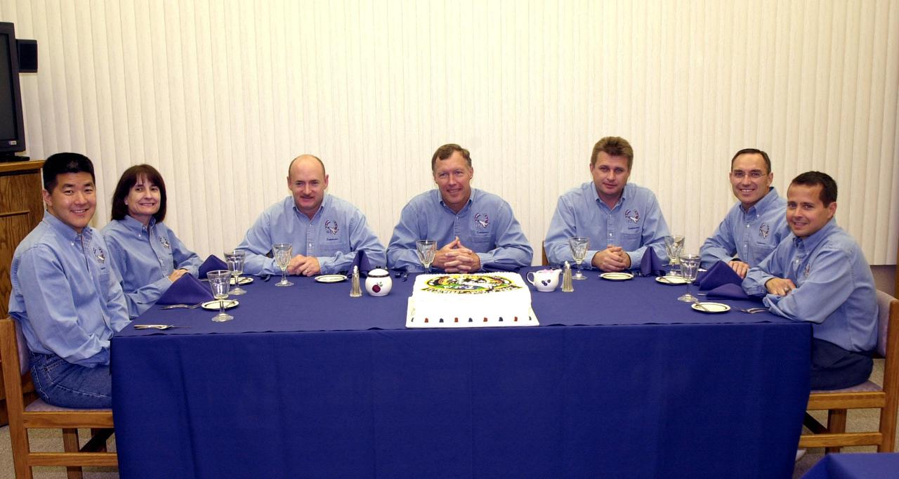 KENNEDY SPACE CENTER, Fla. -- Gathered for a second day after a scrub due to weather conditions, the STS-108 crew again enjoy a pre-launch snack featuring a cake with the mission patch. Seated left to right are Mission Specialists Daniel M. Tani and Linda A. Godwin, Pilot Mark E. Kelly and Commander Dominic L. Gorie; the Expedition 4 crew Commander Yuri Onufrienko and astronauts Carl E. Walz and Daniel W. Bursch. Top priorities for the STS-108 (UF-1) mission of Endeavour are rotation of the International Space Station Expedition 3 and Expedition 4 crews; bringing water, equipment and supplies to the station in the Multi-Purpose Logistics Module Raffaello; and the crew's completion of robotics tasks and a spacewalk to install thermal blankets over two pieces of equipment at the bases of the Space Station's solar wings. Launch is scheduled for 5:19 p.m. EST (22:19 GMT) Dec .5, 2001, from Launch Pad 39B