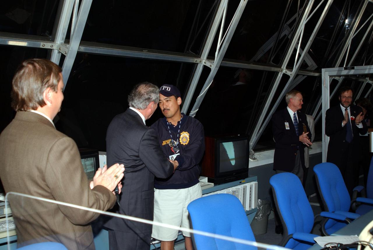 KENNEDY SPACE CENTER, Fla. -- New York Police Department Detective Michael Jermyn (center) is thanked for representing the New York Police and Fire Departments at the launch of Space Shuttle Endeavour on mission STS-108.  Offering his handshake is NASA's Acting Administrator Daniel Mulville; Launch Director Mike Leinbach (left) applauds.  At right is Center Director Roy Bridges Jr. Jermyn praised the efforts of the workers on the successful launch. Endeavour is carrying 6,000 flags that will be given to the families of those who died in the fall of the Twin Towers.  Liftoff of Endeavour occurred at 5:19:28 p.m. EST (22:19.28 GMT).  Endeavour will dock with the International Space Station on Dec. 7. STS-108 is the final Shuttle mission of 2001and the 107th Shuttle flight overall.  It is the 12th flight to the Space Station.  Landing of the orbiter at KSC's Shuttle Landing Facility is targeted for 1:05 p.m. EST (18:05 p.m. GMT) Dec. 16