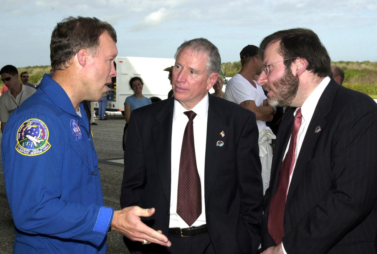 KENNEDY SPACE CENTER, FLA. --  After a successful landing at the KSC Shuttle Landing Facility, completing mission STS-108, Commander Dominic L. Gorie (left) talks with Acting NASA Administrator Daniel Mulville (center) and White House liaison Courtney Stadd.  Endeavour carried both the mission crew and the Expedition 3 crew -- Commander Frank Culbertson and cosmonauts Vladimir Dezhurov and Mikhail Tyurin -- who returned to Earth after 129 days on the International Space Station.  Completing a mission-elapsed time of 11 days, 19 hours and 35 minutes, Endeavour had main gear touchdown at 12:55:10 p.m. EST (17:55:10 GMT).  Nose gear touchdown occurred at 12:55:23 p.m. (17:55:23 GMT); wheel stop at 12:56:13 p.m. (17:56:13 GMT). Rollout distance was 8,941 feet.  The landing is the 57th at KSC in the history of the program   STS-108 was the 12th mission to the Space Station.  This mission was the 107th flight in the Shuttle program and the 17th flight for the orbiter