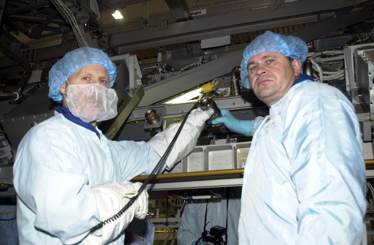 KENNEDY SPACE CENTER, FLA. -- Members of the Expedition 6 crew look over equipment they will be handling during their residency on the International Space Station. At left is Commander Ken Bowersox; at right is cosmonaut Nikolai Budarin. The third crew member (not shown) is astronaut Donald Thomas. The Expedition 6 crew is attached to mission STS-113, scheduled to launch in September 2002.