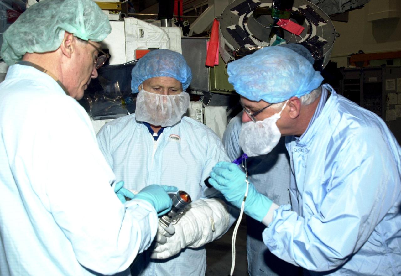 KENNEDY SPACE CENTER, FLA. -- Members of the Expedition 6 crew look over equipment they will be handling during their residency on the International Space Station. Holding equipment (center) is Commander Ken Bowersox. Other crew members are Nikolai Budarin and Donald Thomas. The Expedition 6 crew is attached to mission STS-113, scheduled to launch in September 2002