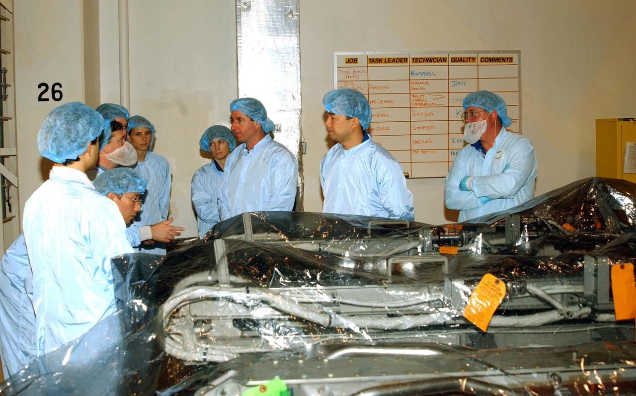 KENNEDY SPACE CENTER, FLA. -- During training at KSC, STS-114 crew members get instructions from a KSC worker.  In the center are Commander Eileen Collins, and Mission Specialists Stephen Robinson and Soichi Noguchi, who is with the National Space and Development Agency of Japan. STS-114 is a utilization and logistics flight that will carry Multi-Purpose Logistics Module Raffaello and the External Stowage Platform (ESP-2), plus the Expedition 7 crew to the International Space Station.  Launch of STS-114 is currently scheduled for January 2003