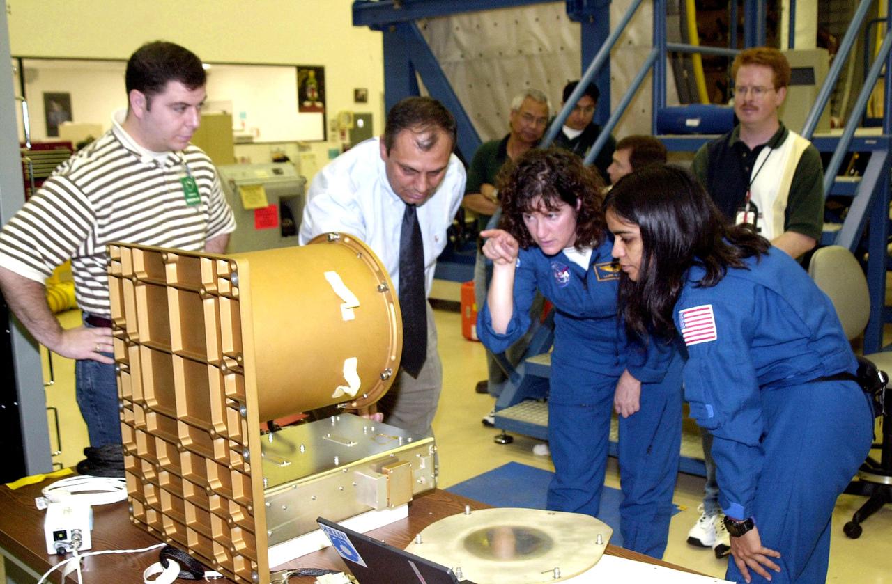 KENNEDY SPACE CENTER, FLA. - At SPACEHAB, Cape Canaveral, Fla., members of the STS-107 crew familiarize themselves with experiments and equipment for the mission. Pointing at a piece of equipment (center) is Mission Specialist Laurel Clark . At right is Mission Specialist Kalpana Chawla. STS-107 is a research mission. The primary payload is the first flight of the SHI Research Double Module (SHI_RDM). The experiments range from material sciences to life sciences (many rats). Also part of the payload is the Fast Reaction Experiments Enabling Science, Technology, Applications and Research (FREESTAR) that incorporates eight high priority secondary attached shuttle experiments: Mediterranean Israeli Dust Experiment (MEIDEX), Shuttle Ozone Limb Sounding Experiment (SOLSE-2), Student Tracked Atmospheric Research Satellite for Heuristic International Networking Experiment (STARSHINE), Critical Viscosity of Xenon-2 (CVX-2), Solar Constant Experiment-3 (SOLOCON-3), Prototype Synchrotron Radiation Detector (PSRD), Low Power Transceiver (LPT), and Collisions Into Dust Experiment -2 (COLLIDE-2). STS-107 is scheduled to launch in July 2002