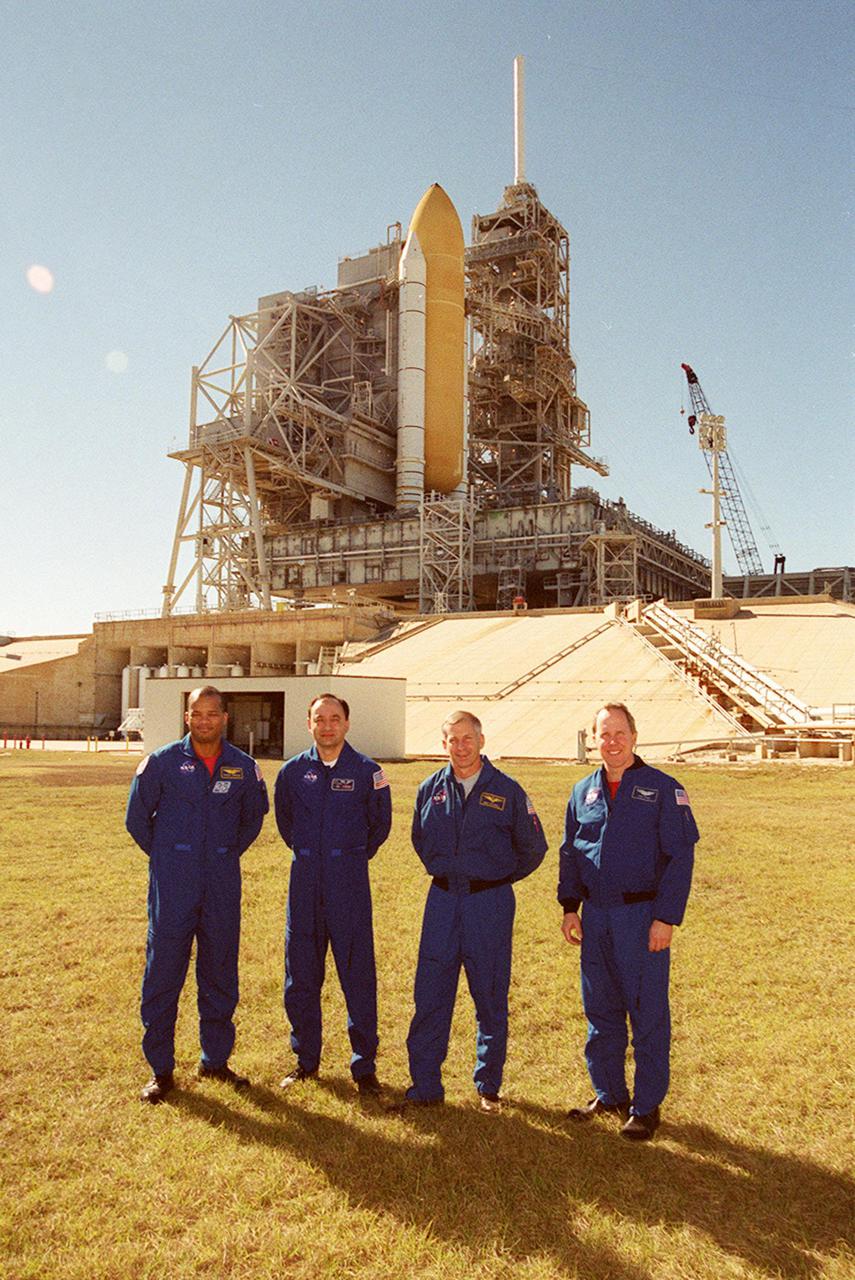 KENNEDY SPACE CENTER, FLA. -- Four members of the STS-98 crew pose for a photo at Launch Pad 39A. Standing, left to right, are Mission Specialist Robert Curbeam, Pilot Mark Polansky, Commander Ken Cockrell and Mission Specialist Thomas Jones. Not pictured is Mission Specialist Marsha Ivins. The crew is at KSC to take part in Terminal Countdown Demonstration Test activities, which include emergency egress training and a simulated launch countdown. STS-98 is the seventh construction flight to the International Space Station, carrying as payload the U.S. Lab Destiny, a key element in the construction of the ISS. Launch of STS-98 is scheduled for Jan. 19 at 2:11 a.m