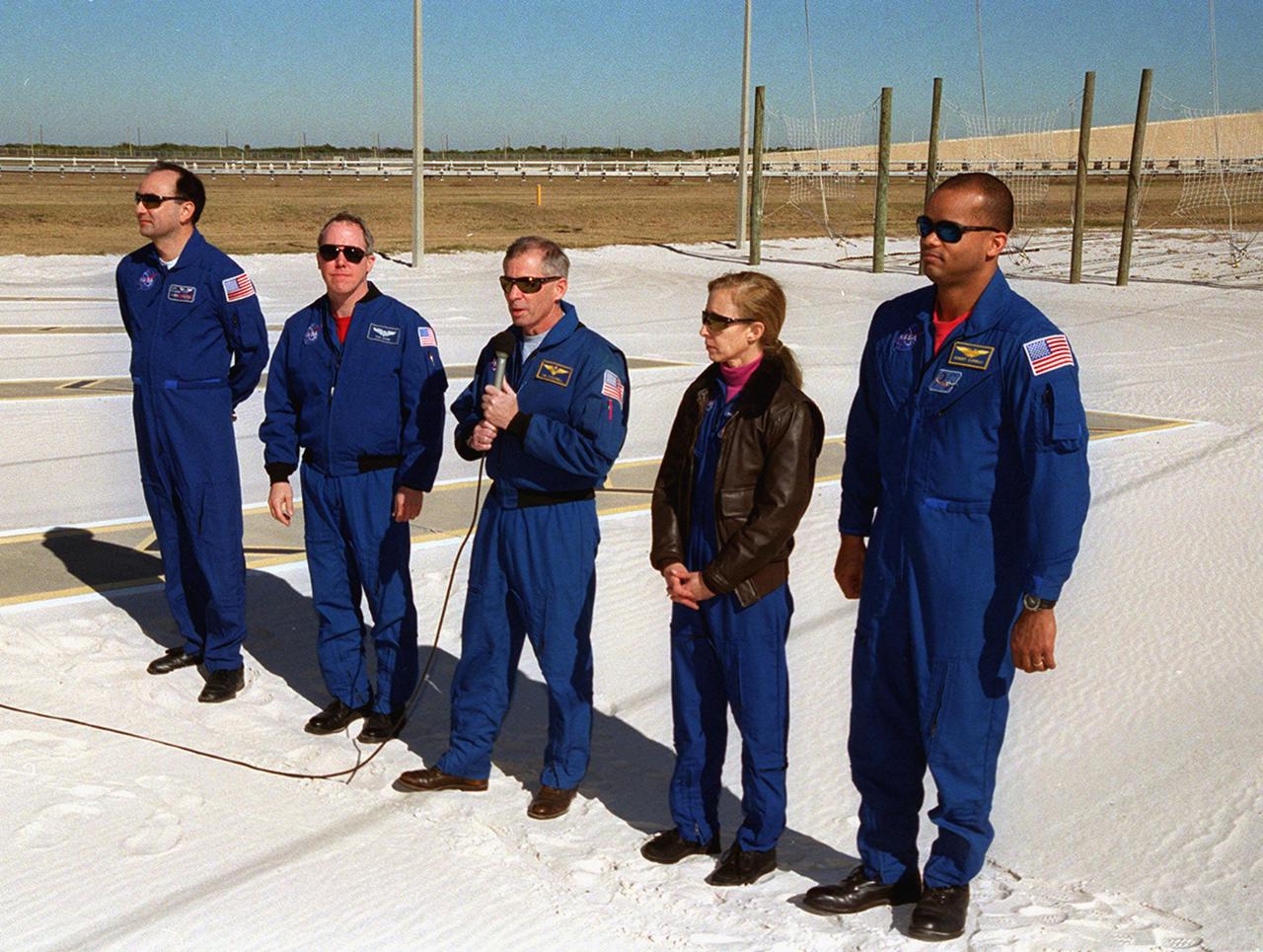 KENNEDY SPACE CENTER, FLA. -- The STS-98 crew talks to the press at a briefing at Launch Pad 39A. Holding the microphone is Commander Ken Cockrell, who answers a question about the mission. The other crew members are (left to right) Pilot Mark Polansky, Mission Specialist Thomas Jones, [Cockrell], and Mission Specialists Marsha Ivins and Robert Curbeam. They are at KSC to take part in Terminal Countdown Demonstration Test activities, which include emergency egress training and a simulated launch countdown. STS-98 is the seventh construction flight to the International Space Station, carrying as payload the U.S. Lab Destiny, a key element in the construction of the ISS. Launch of STS-98 is scheduled for Jan. 19 at 2:11 a.m