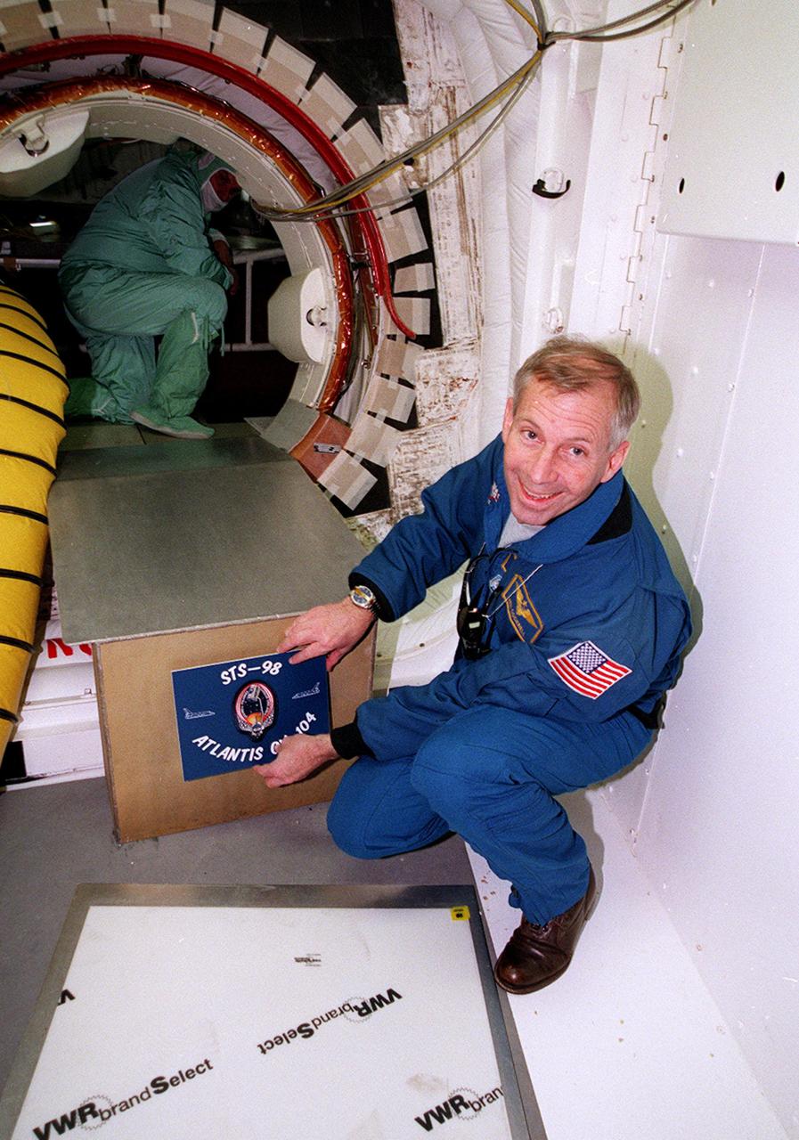 KENNEDY SPACE CENTER, FLA. -- STS-98 Commander Ken Cockrell places the mission patch on the entrance to the orbiter Atlantis. He and the rest of the crew Pilot Mark Polansky and Mission Specialists Thomas Jones, Marsha Ivins and Robert Curbeam are t KSC to take part in Terminal Countdown Demonstration Test activities, which include emergency egress training and a simulated launch countdown. STS-98 is the seventh construction flight to the International Space Station, carrying as payload the U.S. Lab Destiny, a key element in the construction of the ISS. Launch of STS-98 is scheduled for Jan. 19 at 2:11 a.m