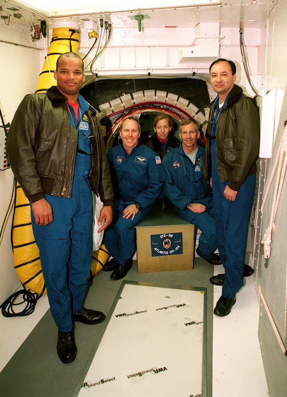 KENNEDY SPACE CENTER, FLA. -- Sitting in the entrance to the orbiter Atlantis are (left to right) STS-98 Mission Specialists Thomas Jones and Marsha Ivins and Commander Ken Cockrell. Below them is the mission patch just placed there by Cockrell. Standing at left is Mission Specialist Robert Curbeam and at right Pilot Mark Polansky. The crew is at KSC to take part in Terminal Countdown Demonstration Test activities, which include emergency egress training and a simulated launch countdown. STS-98 is the seventh construction flight to the International Space Station, carrying as payload the U.S. Lab Destiny, a key element in the construction of the ISS. Launch of STS-98 is scheduled for Jan. 19 at 2:11 a.m