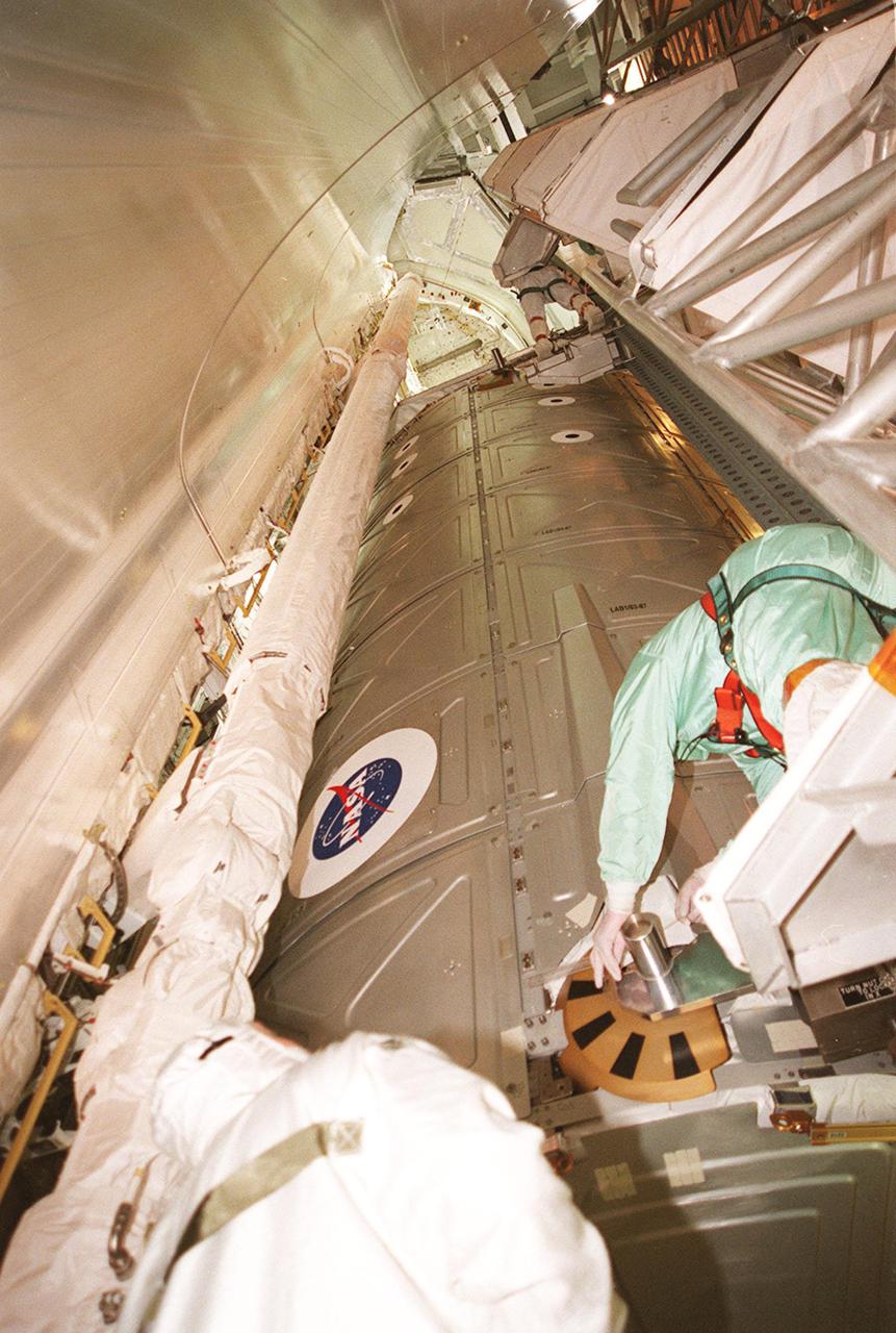 KENNEDY SPACE CENTER, FLA. -- Workers check out the U.S. Lab Destiny after it has been installed in Atlantis’ payload bay at the pad. Destiny, a key element in the construction of the International Space Station, is 28 feet long and weighs 16 tons. This research and command-andcontrol center is the most sophisticated and versatile space laboratory ever built. It will ultimately house a total of 23 experiment racks for crew support and scientific research. STS-98 is the seventh construction flight to the ISS. Launch of STS-98 is scheduled for Jan. 19 at 2:11 a.m. EST