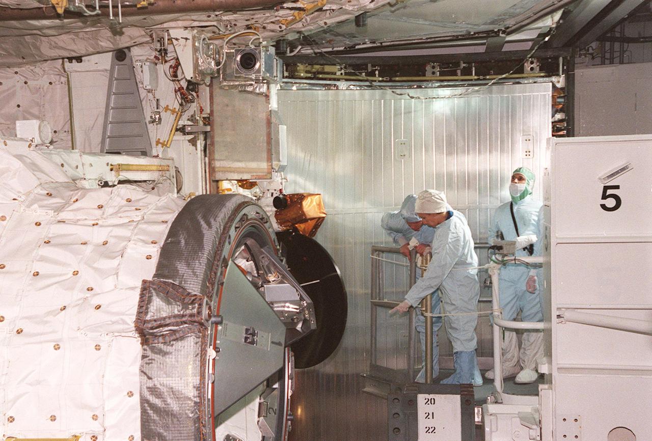 KENNEDY SPACE CENTER, FLA. -- STS-98 Mission Specialist Marsha Ivins (center, pointing) checks out the U.S. Lab Destiny in the payload bay of the orbiter Atlantis. The crew is at KSC for Terminal Countdown Demonstration Test activities, which also include a simulated launch countdown. Destiny, a key element in the construction of the International Space Station, is a pressurized module designed to accommodate pressurized payloads. It has a capacity of 24 rack locations. Payload racks will occupy 13 locations especially designed to support experiments. The module already has five system racks installed inside. Launch of STS-98 on its 11-day mission is scheduled for Jan. 19 at 2:11 a.m. EST