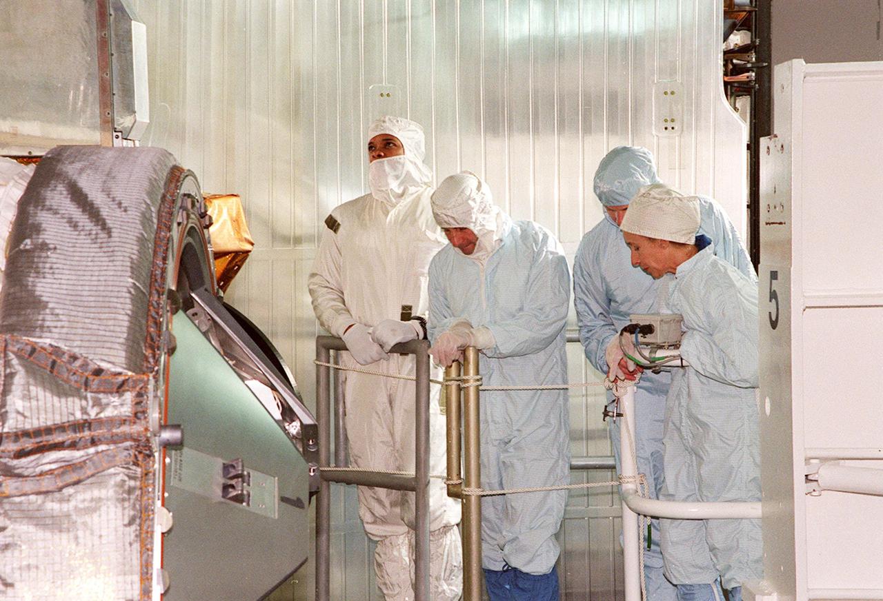 KENNEDY SPACE CENTER, FLA. -- STS-98 Mission Specialist Robert Curbeam (left), Commander Ken Cockrell (center) and Mission Specialist Marsha Ivins (right) look over the U.S. Lab Destiny in the payload bay of the orbiter Atlantis. Behind Ivins is Scott Thurston, of the VITT office. The crew is at KSC for Terminal Countdown Demonstration Test activities, which also include a simulated launch countdown. A key element in the construction of the International Space Station, Destiny is a pressurized module designed to accommodate pressurized payloads. It has a capacity of 24 rack locations. Payload racks will occupy 13 locations especially designed to support experiments. The module already has five system racks installed inside. Launch of STS-98 on its 11-day mission is scheduled for Jan. 19 at 2:11 a.m. EST